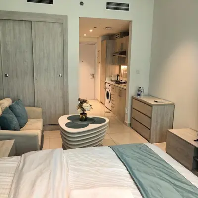 a bedroom with a bed and a living room at Seven Palm Jumeirah Studio in Dubai