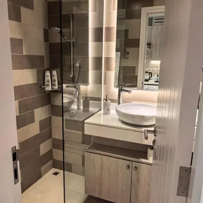 a bathroom with a sink and a glass shower at Seven Palm Jumeirah Studio in Dubai