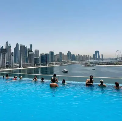 a group of people in a swimming pool with a city skyline at Seven Palm Jumeirah Studio in Dubai