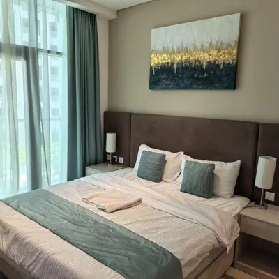 a bedroom with a large bed with two lamps at Seven Palm Jumeirah Studio in Dubai
