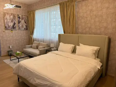 a bedroom with a large bed and a couch at Champion Tower 1 Sports city By Al sarya Holiday Homes in Dubai
