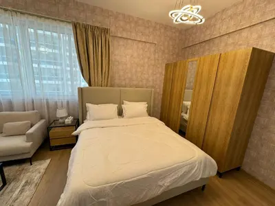 a bedroom with a bed and a chair and a window at Champion Tower 1 Sports city By Al sarya Holiday Homes in Dubai