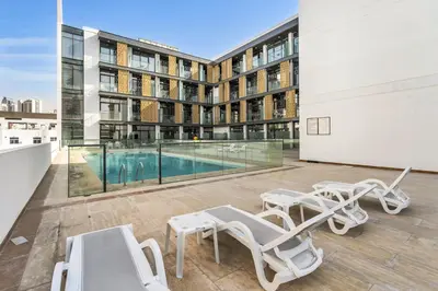 an apartment patio with chairs and a swimming pool at DAYF-SER03 Brand New Studio with Balcony in JVC in Dubai