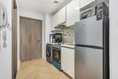 a kitchen with a refrigerator and a stove at DAYF-SER03 Brand New Studio with Balcony in JVC in Dubai