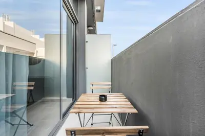 a wooden table and benches on a balcony at DAYF-SER03 Brand New Studio with Balcony in JVC in Dubai