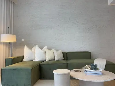 a living room with a green couch and a table at Prestige stay next to Burj Khalifa in Dubai