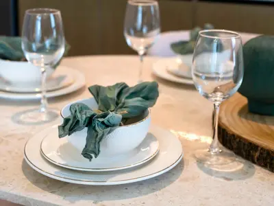 a table with wine glasses and a bowl with a plant in it at Prestige stay next to Burj Khalifa in Dubai