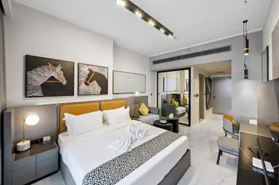 a bedroom with a bed and a living room at Luxury Escapes Modern Studio MAG 318 in Dubai