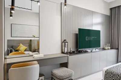 a bedroom with a bed and a desk with a monitor at Luxury Escapes Modern Studio MAG 318 in Dubai