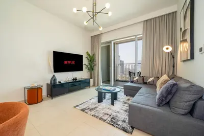 a living room with a couch and a tv at Zapbed House -Stylish 1 BR Apartment Downtown Views II Tower 2 in Dubai