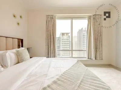 a bedroom with a white bed and a large window at Cozy 1BR in Burj Views I Top Location Walk to Dubai Mall & Burj Khalifa I Wi-Fi in Dubai