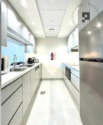 a large kitchen with white cabinets and a sink at Cozy 1BR in Burj Views I Top Location Walk to Dubai Mall & Burj Khalifa I Wi-Fi in Dubai