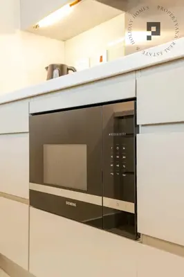 a microwave oven on a counter in a kitchen at Cozy 1BR in Burj Views I Top Location Walk to Dubai Mall & Burj Khalifa I Wi-Fi in Dubai