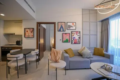 a living room with a couch and a table and chairs at Bnbeyond's Canal Dreams and Luxe 2BR in Dubai