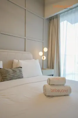 a white bed with two towels on top of it at Bnbeyond's Canal Dreams and Luxe 2BR in Dubai