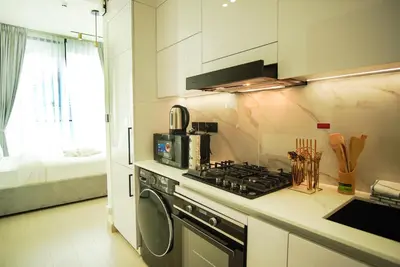 a kitchen with a stove and a washing machine at Brand New Studio In Tulip JVC in Dubai