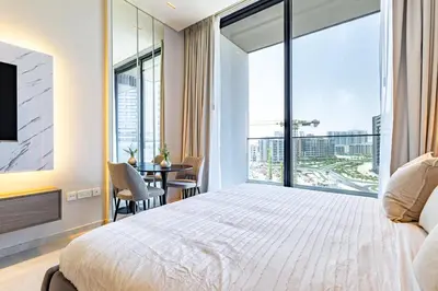 a bedroom with a large bed and a table with chairs at SuperHost- Modern Studio in Arjan with pool & Gym in Dubai