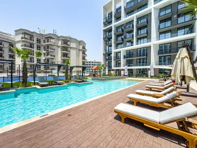 a swimming pool with lounge chairs in a building at SuperHost- Modern Studio in Arjan with pool & Gym in Dubai