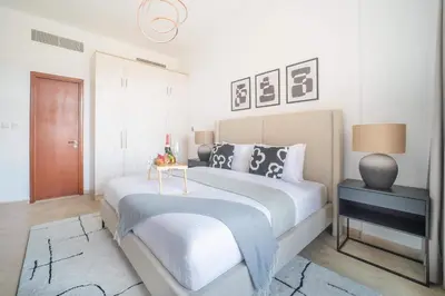 a bedroom with a large bed with a blue blanket on it at Cozy 1BR in the Peaceful Community of Motor City in Dubai