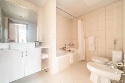 a bathroom with a sink and a toilet and a tub at Cozy 1BR in the Peaceful Community of Motor City in Dubai