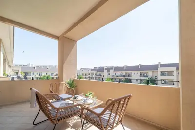 a patio with a table and chairs on a balcony at Cozy 1BR in the Peaceful Community of Motor City in Dubai