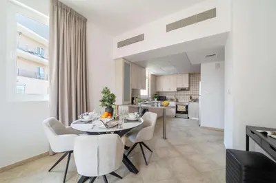 a kitchen and dining room with a table and chairs at Cozy 1BR in the Peaceful Community of Motor City in Dubai