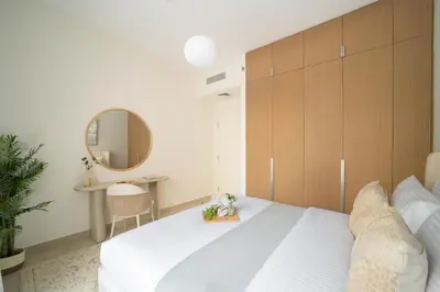 a bedroom with a white bed and a mirror at Frank Porter - Groove at Creek Beach in Dubai