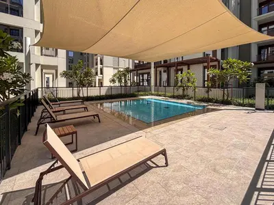 a swimming pool with chairs and a large umbrella at Frank Porter - Groove at Creek Beach in Dubai