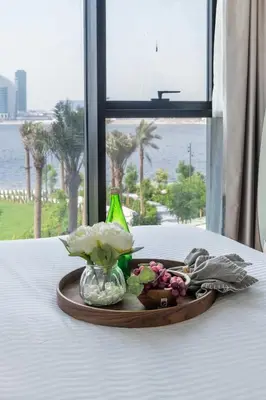 a plate of flowers on a table with a window at Frank Porter - Creek Crescent Tower 1 in Dubai
