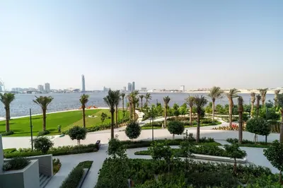a view of a park with palm trees and the water at Frank Porter - Creek Crescent Tower 1 in Dubai