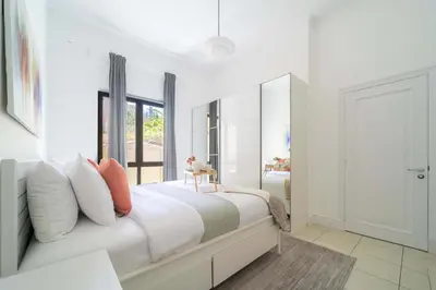 a white bedroom with a large bed and a mirror at Frank Porter - Zaafaran 4, Old town, Downtown Dubai in Dubai
