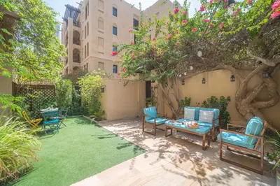 a yard with chairs and a tree with flowers at Frank Porter - Zaafaran 4, Old town, Downtown Dubai in Dubai