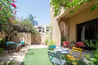 a patio with a table and chairs on the grass at Frank Porter - Zaafaran 4, Old town, Downtown Dubai in Dubai