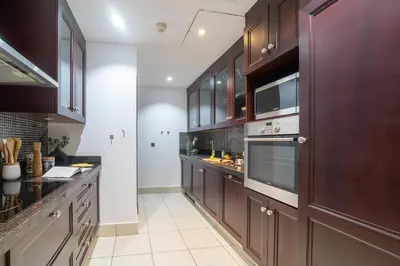 a large kitchen with brown cabinets and appliances at Frank Porter - Zaafaran 4, Old town, Downtown Dubai in Dubai
