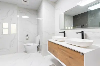 a white bathroom with two sinks and a toilet at Seashell stunning 2 bedrooms in JBR in Dubai