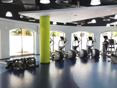 a gym with several tread machines and a yellow pole at Seashell stunning 2 bedrooms in JBR in Dubai
