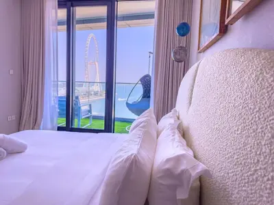 a bedroom with a bed with a view of a wheel at ADDRESS BEACH RESORT Residence Million Dollar Sea and Palm View DXB AIRPORT VIP Shuttle option in Dubai
