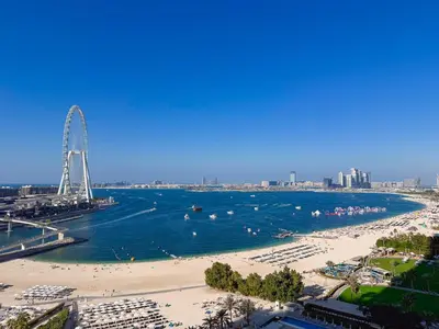 a view of a beach with a ferris wheel in the distance at ADDRESS BEACH RESORT Residence Million Dollar Sea and Palm View DXB AIRPORT VIP Shuttle option in Dubai