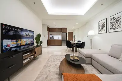 a living room with a couch and a flat screen tv at Brand New Stylish 1-Bed Getaway with Private Beach and Palm Views in Dubai