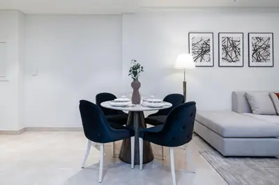 a living room with a table and chairs and a couch at Brand New Stylish 1-Bed Getaway with Private Beach and Palm Views in Dubai