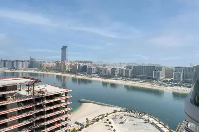 a view of a city and a river with buildings at Brand New Stylish 1-Bed Getaway with Private Beach and Palm Views in Dubai