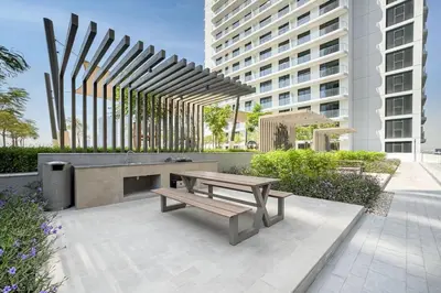 a patio with a bench and a table and a building at Brand New Stylish 1-Bed Getaway with Private Beach and Palm Views in Dubai