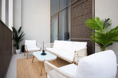 a balcony with white chairs and tables and plants at Creek New Luxury Stay Beach and Lagoona Access in Dubai