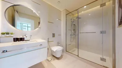a bathroom with a shower and a toilet and a mirror at Vacationer I Luxurious 1 Bedroom Apartment I Private Beach and Infinity Pool Access in Dubai