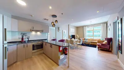 an open kitchen and living room with a dining room at Vacationer I Steps to Metro I Premium 2 Bedroom Apartment I Yacht Bay Marina in Dubai