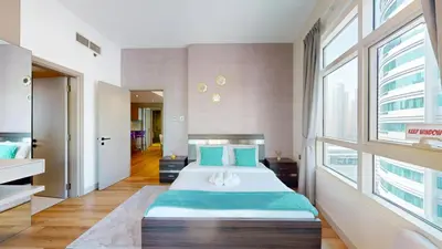 a bedroom with a large bed and a large window at Vacationer I Steps to Metro I Premium 2 Bedroom Apartment I Yacht Bay Marina in Dubai