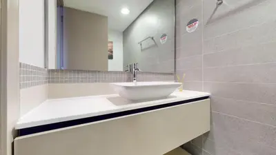 a white bathroom with a sink and a mirror at Vacationer I Steps to Metro I Premium 2 Bedroom Apartment I Yacht Bay Marina in Dubai