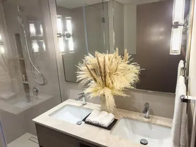 a bathroom with a sink with a mirror and a shower at GRANDE SIGNATURE with a direct Burj Khalifa view and Private Fountain Show with DXB AIRPORT VIP Shuttle option for 6 guests in Dubai