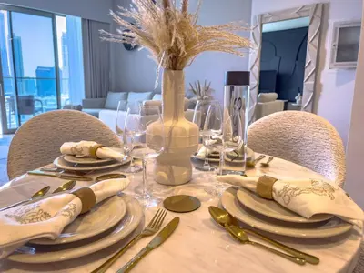 a wooden table with plates and utensils on it at GRANDE SIGNATURE with a direct Burj Khalifa view and Private Fountain Show with DXB AIRPORT VIP Shuttle option for 6 guests in Dubai