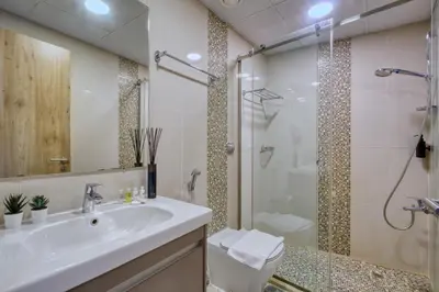 a bathroom with a sink and a shower at Vibrant Waterfront Duplex in Dubai Marina in Dubai